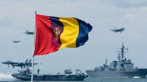 Steagul României flutură lângă avioane și nave militare.